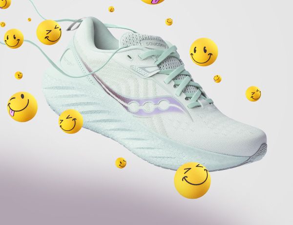 A white Saucony Triumph running shoe with yellow smileys around it.