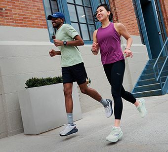 Two people running on a street.