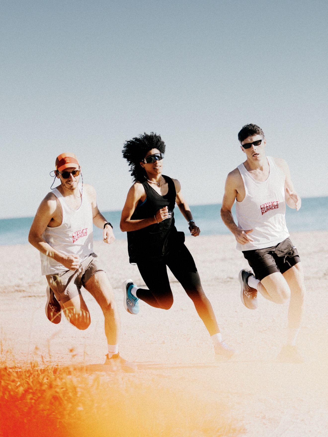 a group of people running on a beach