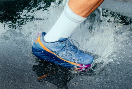 a person's foot in a blue shoe splashing water